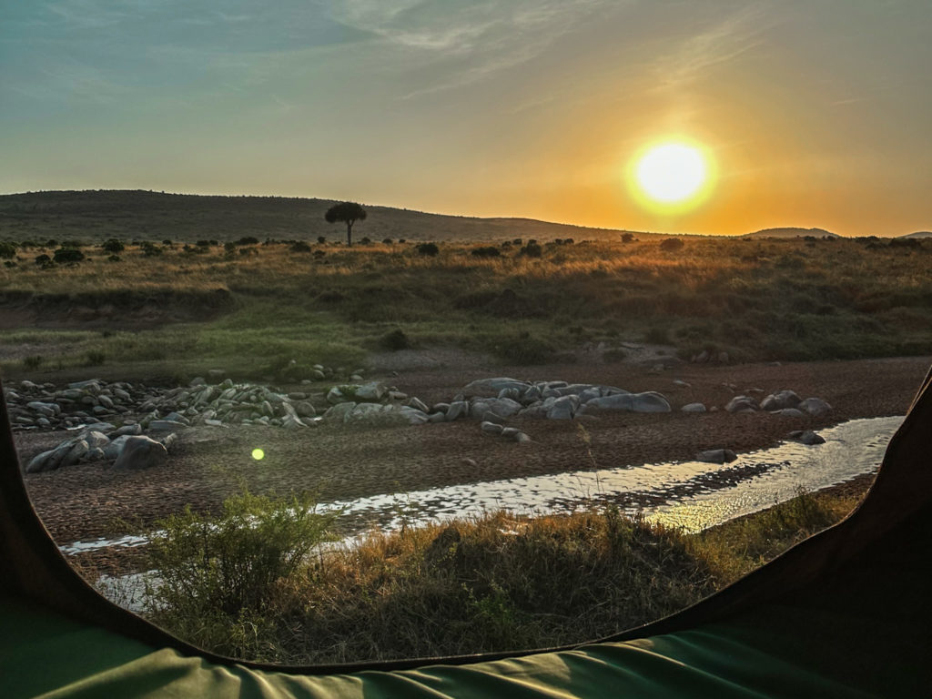 View out of the tent of a camping 4x4 vehicle while traveling Kenya on a budget safari experience.