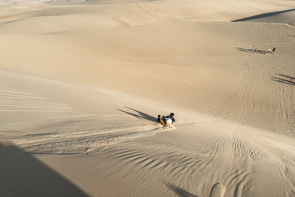 Huacachina Travel Guide: Sandboarding down the dunes in Huacachina